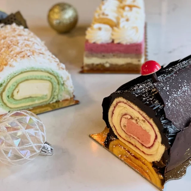 It is with extraordinary pleasure that we introduce three new Bûche de Noël cakes for the holiday season! Each one is handcrafted with layers of refined flavors, lush textures, and the perfect amount of festive magic:

Cherry Cordial Bûche
A twist on our classic Bûche de Noel! Almond roulade, soaked with Amaretto simple syrup, layered with our tart cherry jam & Amaretto crème Madame around a cherry mousse center. Finished with Chocolate Ganache.

Tropical Bûche
A ray of sunshine for your winter table. Lime Chiffon cake soaked in a rum simple syrup, layered with pineapple coulis & passionfruit mousse.  Finished in coconut Chantilly and toasted coconut.

Cranberry Orange Spice Bûche
Sophisticated Holiday comfort. Orange Spice Chiffon cake, soaked with orange simple syrup, layered between a sweet orange marmalade and a vanilla crème madame. Topped with a cranberry mousse and vanilla cinnamon Chantilly.

Available online and all 3 shops.